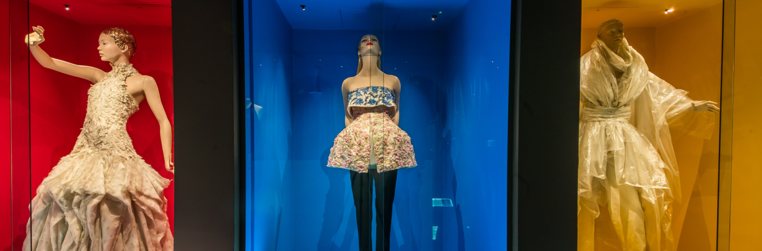 Three outfits from the Dress of the Year collection on display