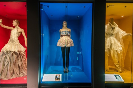 Three outfits from the Dress of the Year collection are shown on display