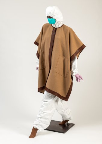 Mannequin wearing a brown cape, white hooded suit and a blue facemask